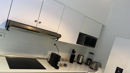 a kitchen with white cabinets and a microwave at Odivelas Place 1 in Odivelas