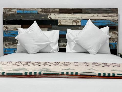 un letto con cuscini bianchi e testiera in legno di Terima Kasih Malang by Zzz a Malang