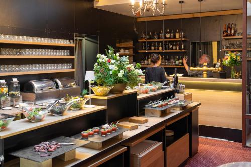 a restaurant with a counter with flowers on it at Maxmilian Lifestyle Resort in Loučeň