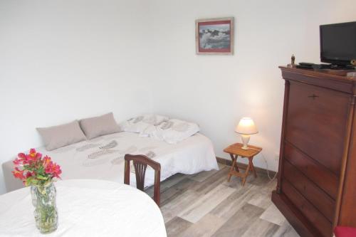 a bedroom with a bed and a table with a vase of flowers at Studio vue mer dans le centre de Crozon in Crozon
