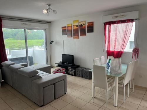un salon avec un canapé et une table dans l'établissement F3 balcons St Jean de Luz, à Saint-Jean-de-Luz