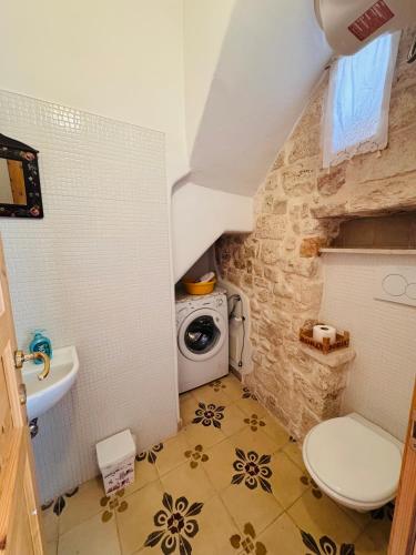 a bathroom with a toilet and a washing machine at Casa Vacanze Moonlight in Polignano a Mare
