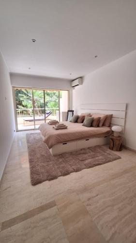 une grande chambre avec un grand lit avec un tapis dans l'établissement Elégant 3 chambres avec terrasse sur jardins à Montfleury, à Cannes