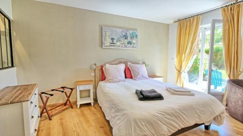 a bedroom with a bed with white sheets and red pillows at Relais Solognot in Sennely