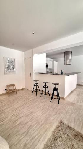 un salon avec deux tables et une cuisine dans l'établissement Elégant 3 chambres avec terrasse sur jardins à Montfleury, à Cannes