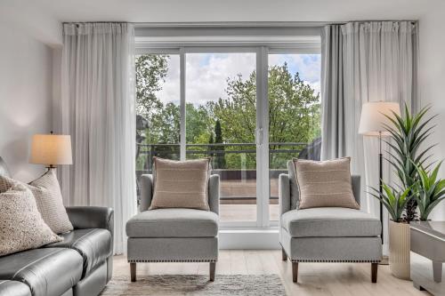a living room with two chairs and a large window at Initial - Valley - MSA in Beaupré