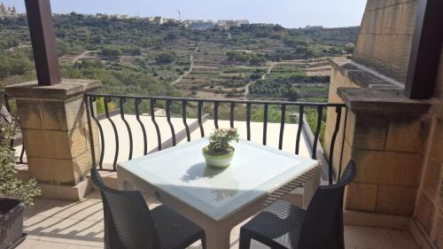 a white table and chairs on a balcony with a view at Aurelia Gozo Boutique BnB in Xagħra