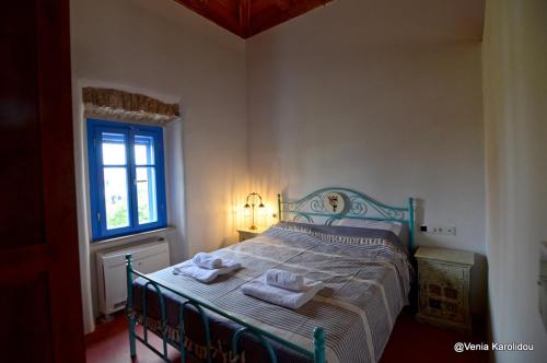 a bedroom with a bed with two towels on it at Rodamia Traditional Cottage in Kythira
