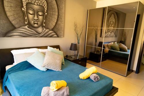 a room with a bed with a large buddha mural at Aurelia Gozo Boutique BnB in Xagħra