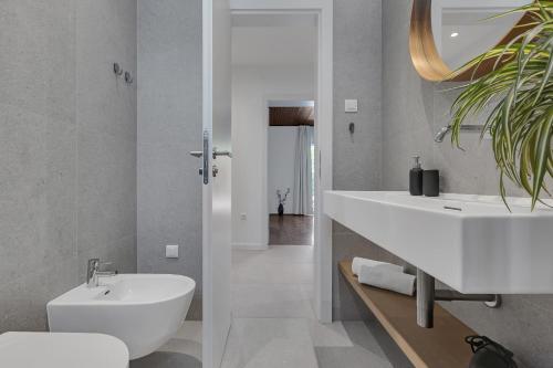 a bathroom with a white sink and a toilet at Apartments Villa Lili in Tučepi