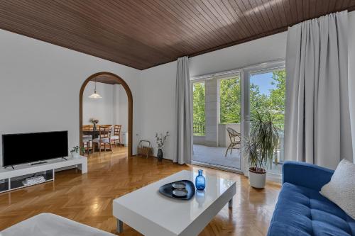 a living room with a blue couch and a table at Apartments Villa Lili in Tučepi