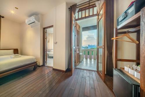 a bedroom with a bed and a door to a balcony at Bigcountry Villa Ayutthaya in Phra Nakhon Si Ayutthaya