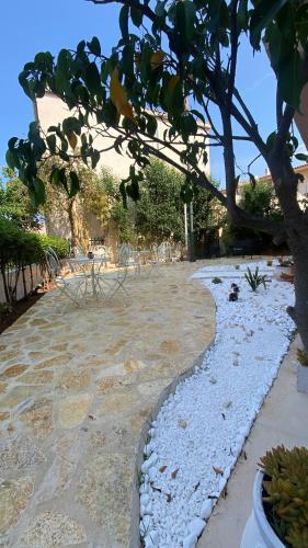 a stone walk way with a tree in the foreground at Hotel Marialena in Ancient Epidavros