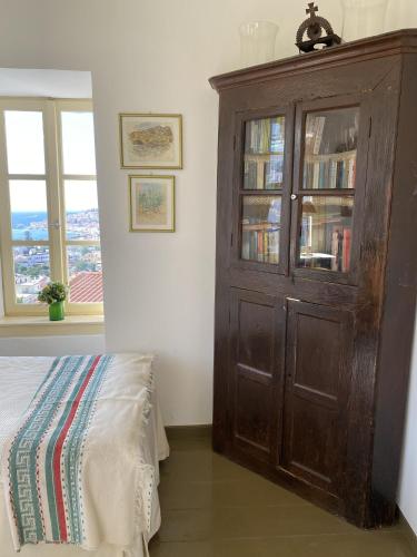 a bedroom with a wooden cabinet with books at A panoramic Aegean Hideaway with pool in Ano Vathi, Samos in Vathý