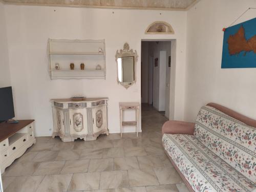 a living room with a couch and a mirror at La Casa del Paese in Favignana