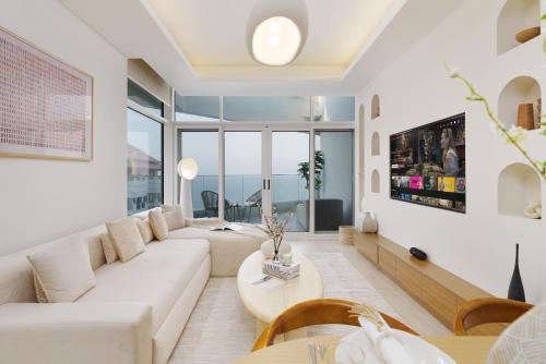 a living room with a couch and a table at Dejaview Stays Luxury Apartment with Private Terrace, Burj & Sea View in Dubai
