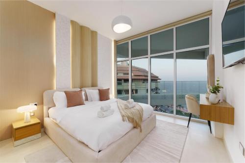 a bedroom with a bed and a large window at Dejaview Stays Luxury Apartment with Private Terrace, Burj & Sea View in Dubai