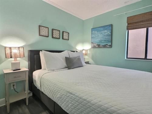 a bedroom with a bed with a white bedspread and a window at Beautiful Two Bedroom, Two Bath Condo at Sailport in Tampa