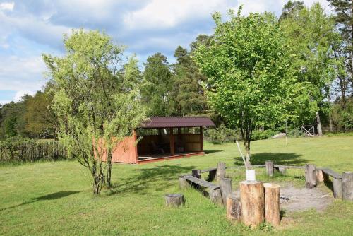 a building in the middle of a field with trees at Chata w lesie in Zagwiździe