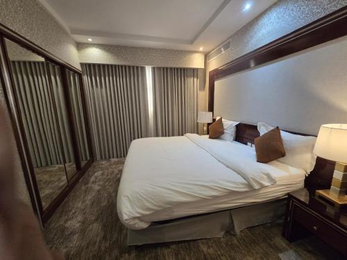 a hotel room with a large bed and a mirror at Ekono Hotel in Jeddah