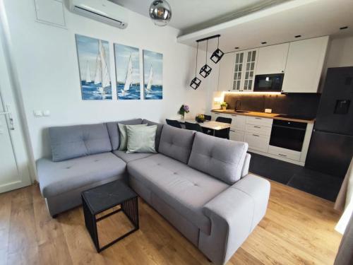 ein Wohnzimmer mit Sofa und eine Küche in der Unterkunft Apartment FortyTwo in Orebić