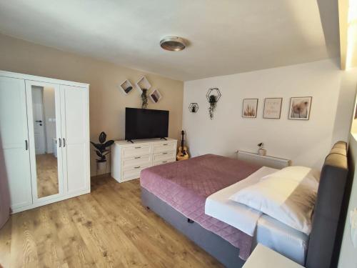 ein Schlafzimmer mit Bett und Flachbildfernseher in der Unterkunft Apartment FortyTwo in Orebić