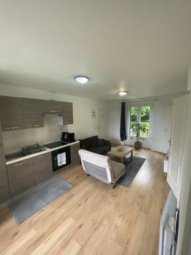 un salon avec un canapé et une cuisine dans l'établissement Appartement Chessy,près de Val D’europe, à Chessy