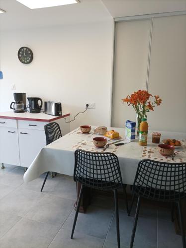 a kitchen with a table and chairs with fruit on it at La sérénité in Les Sables-dʼOlonne