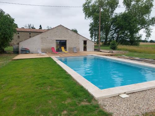 une piscine dans une cour à côté d'une maison dans l'établissement La maison au bout de l'allée, à Carbes