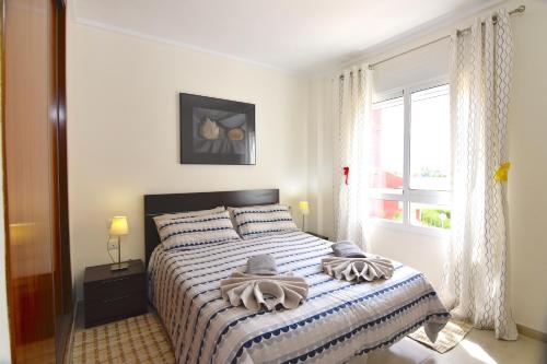 a bedroom with a bed with towels on it at Acogedor apartamento cerca de la playa in Los Alcázares