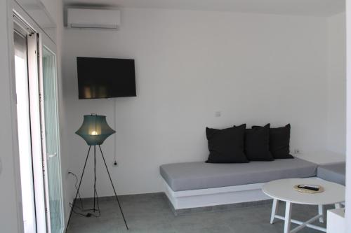 キスノスにあるLefkes Beach Suiteのソファとテーブルとテレビのある部屋