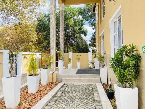 a courtyard with potted plants in front of a house at Henry George Hotel in Pretoria