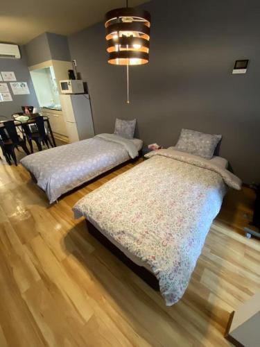 two beds sitting next to each other in a room at Namba Shinsaibashi 10 mins Reiko guest house in Osaka