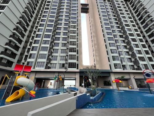 a large apartment building with a pool in front of it at Luxury & Comfy studio in the heart of Melaka in Melaka