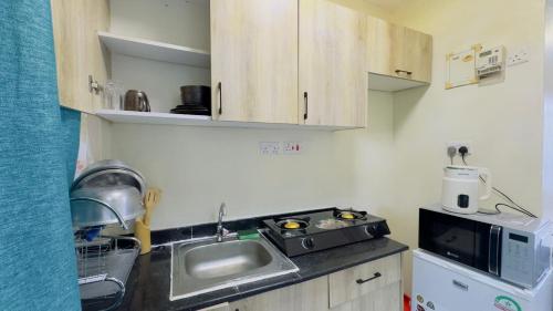 a small kitchen with a sink and a microwave at Studio apartment Westlands Kitisuru in Nairobi