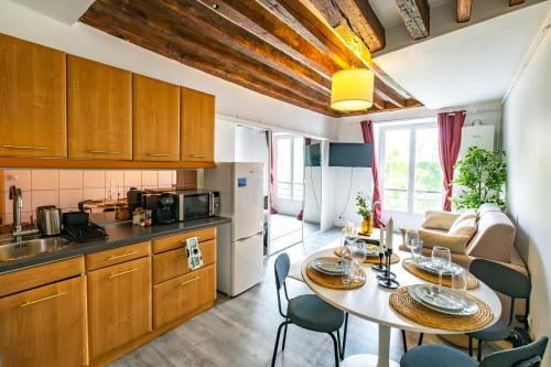 une cuisine et une salle à manger avec une table et des chaises dans l'établissement Peaceful Flat in Montorgueil, à Paris