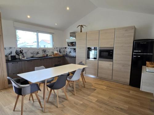 une cuisine avec une table et des chaises dans une cuisine dans l'établissement Le Petit Pre, à Le Fenouiller