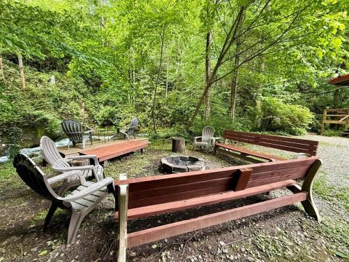 a park with two benches and a fire pit at Buffalo Creek Cabin- Hot Tub Creekfront Escape in Robbinsville