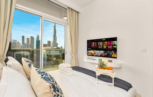 a bedroom with a bed with a large window at Luxury Apartment with Balcony & Full Burj Khalifa View by Dejaview Stays in Dubai