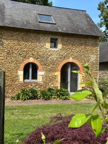 une maison en briques avec des fenêtres et une cour dans l'établissement La Reboursière, à Notre-Dame-du-Pé