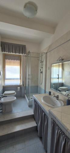 a bathroom with two toilets and a sink and a tub at La Lorenzetta in Civitavecchia