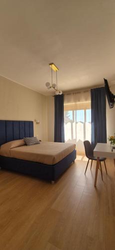 a bedroom with a bed and a chair and a table at La Lorenzetta in Civitavecchia