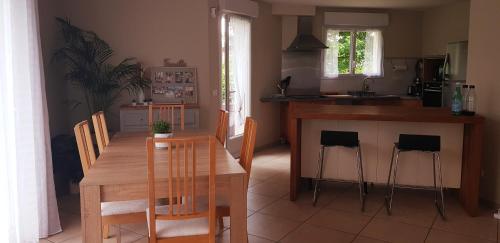 une cuisine et une salle à manger avec une table et des chaises en bois dans l'établissement Maison paisible au cœur du Parc naturel de Chartreuse avec vue sur le Granier, à Chapareillan