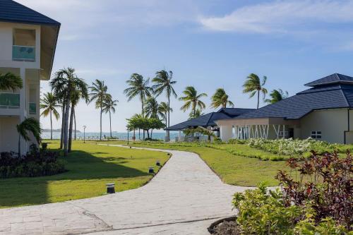 a walkway next to a house and palm trees at Xanadú in Sampiño