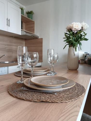 une table avec des assiettes et des verres à vin dessus dans l'établissement Appartement T2 Cosy Hyper Centre proche Aéroport et Gare SNCF, à Beauvais