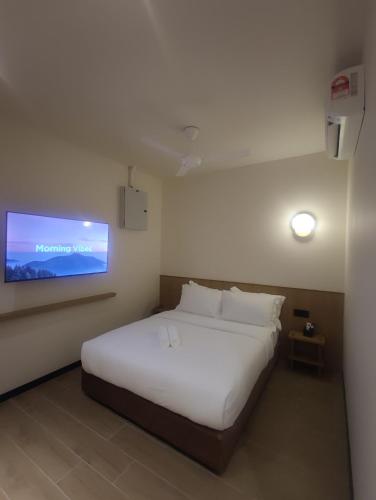 a bedroom with a bed and a tv on the wall at Hotel Mirda Puncak Alam in Bandar Puncak Alam