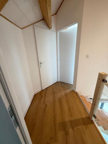 an empty room with a door and a wooden floor at Gulf Stone in Séné