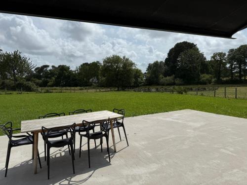 a table and chairs on a patio with a field at Gulf Stone in Séné