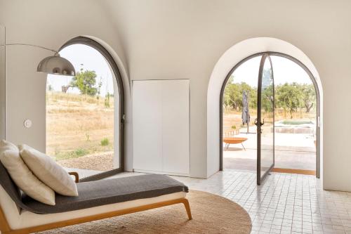 a living room with a bench and an archway at Monte De Santiago in São Domingos