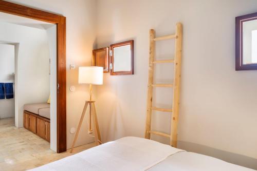 a bedroom with a ladder and a bed and a lamp at Monte De Santiago in São Domingos